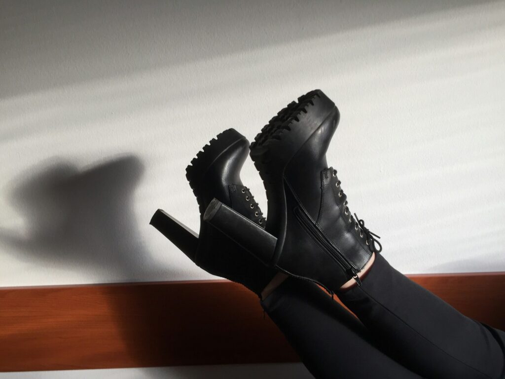 Low Section Of Woman Wearing High Heels Against Wall